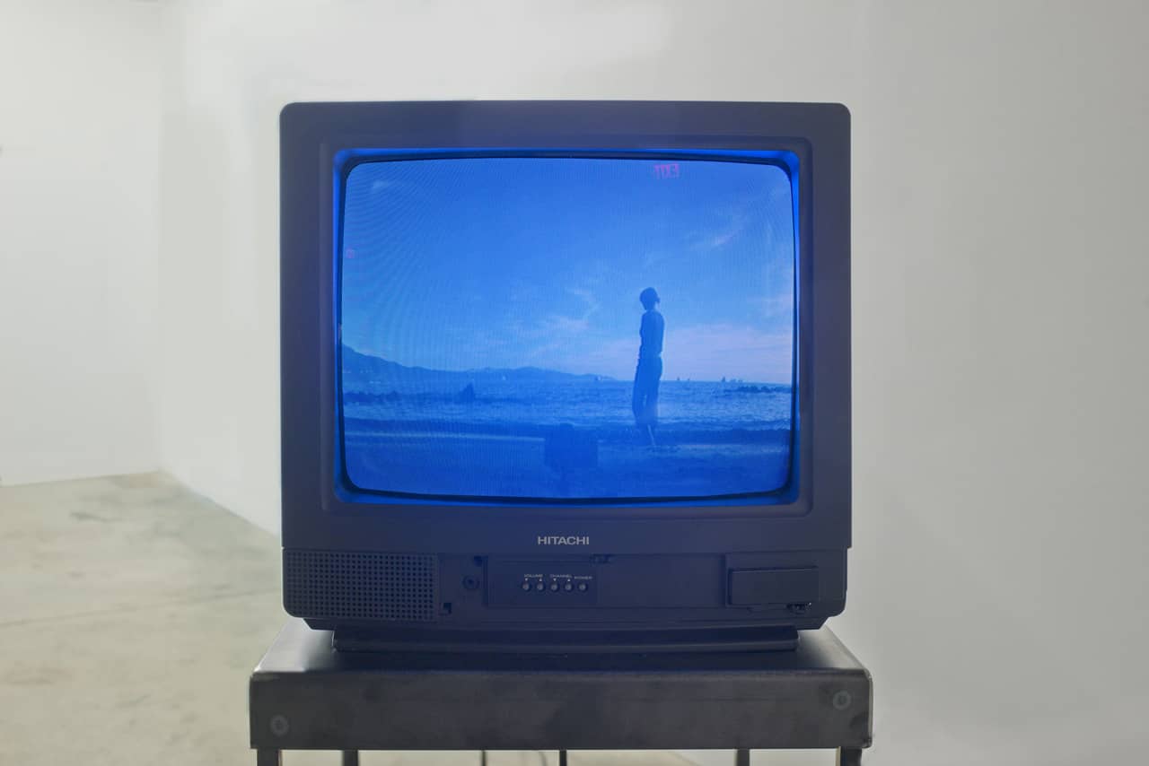 Closeup of a TV with blue image of a seascape with a figure