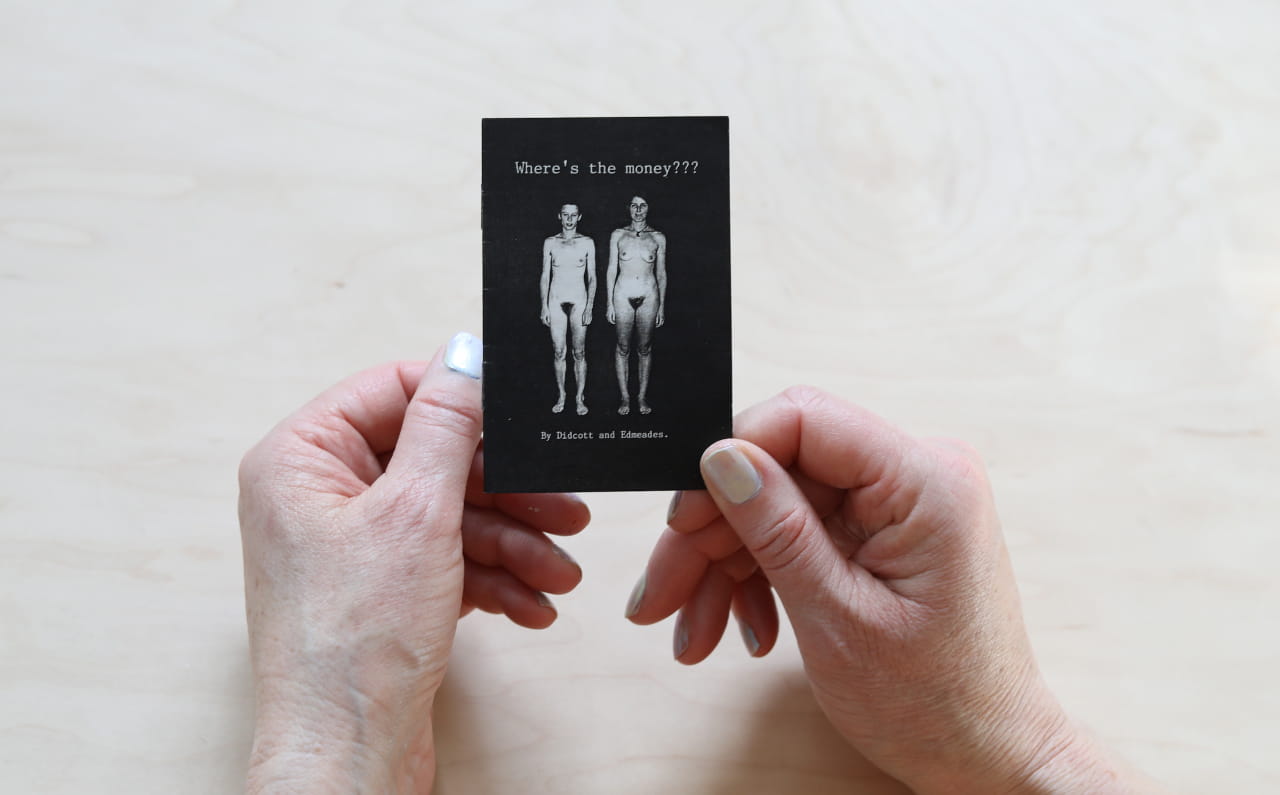 Person holding an artist book, showing 2 nudes in black and white